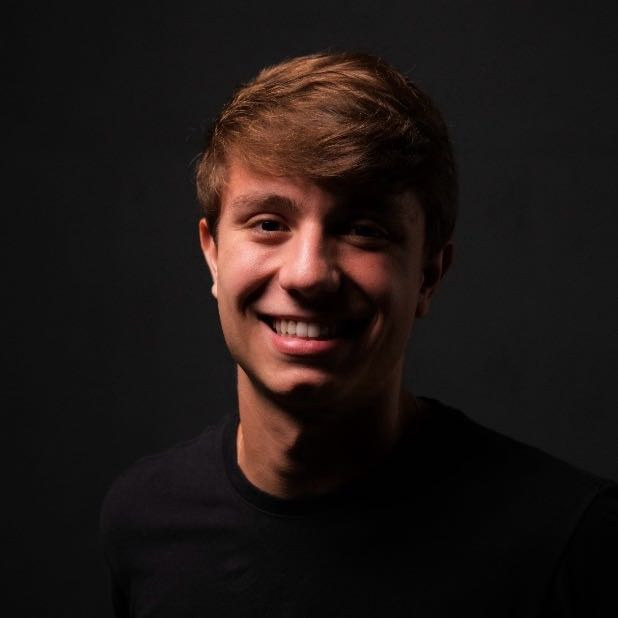 Daniel Antunes, fundador da Clipfy, sorrindo, de camiseta preta em fundo escuro.